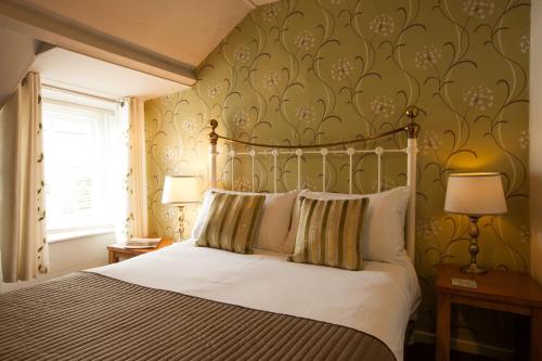 Greenhaugh霍利布什宾馆的一间卧室配有一张床和两张台灯。