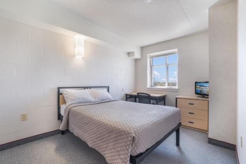威兰韦兰公寓及会议中心 的一间卧室配有一张床和一台电视