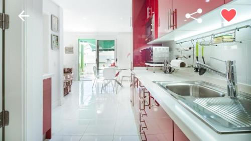 马斯帕洛马斯Bungalow con piscina Maspalomas的厨房配有红色和白色的橱柜和水槽