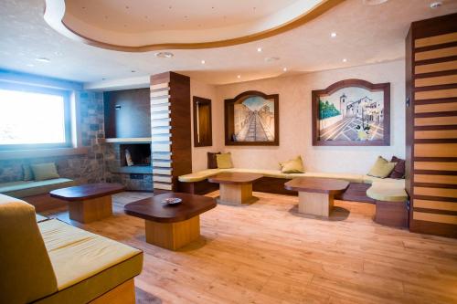 卡普拉科塔Hotel Monte Campo的客厅配有两张桌子和一张沙发