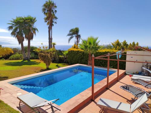 绍萨尔Villa Carioca - with private pool, marvelous garden and amazing ocean view的一个带椅子的游泳池,背景是大海