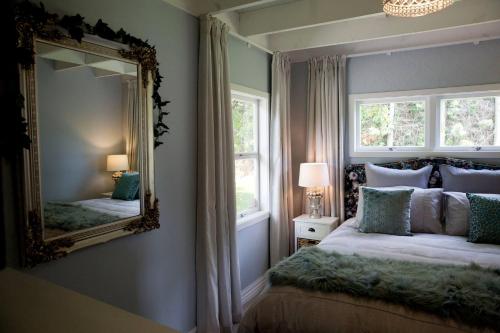 陶朗加Sunny Brae Cottages的一间带大镜子和床的卧室
