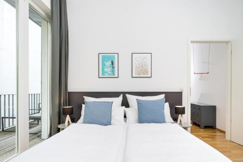 柏林BENSIMON apartments Prenzlauer Berg的卧室配有带蓝色枕头的大型白色床