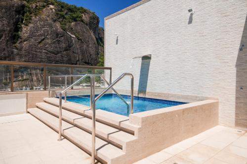 里约热内卢里约热内卢大西洋酒店的一座带楼梯的游泳池,位于大楼旁