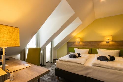 伊尔梅瑙BERG & SPA HOTEL GABELBACH的酒店客房配有两张床和一张书桌