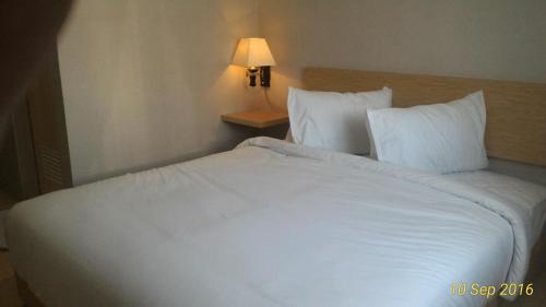 明古鲁省Omnea Hotel - Syariah的一张大白色的床,位于酒店客房内