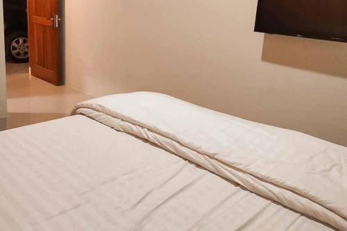 BaoenRedDoorz Syariah @ Haurgeulis的卧室配有一张未铺好的床铺,铺有白色床单