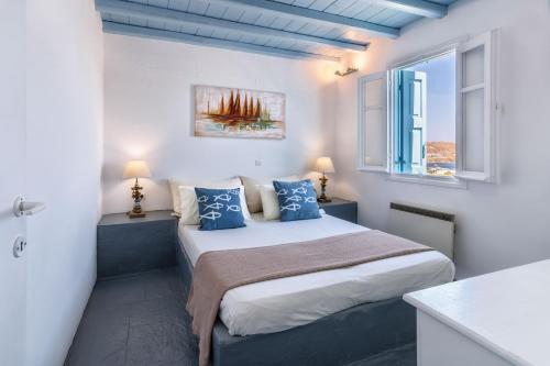 塞里福斯Sea View Villa Serifos Island的一间卧室设有一张床和两个窗户。