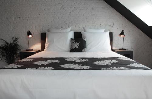 安特卫普国民城市公寓和套房酒店的卧室配有一张带白色床单和枕头的大床。