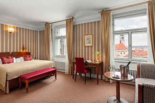 布拉格布拉格巴黎酒店的酒店客房带一张床、一张桌子和椅子