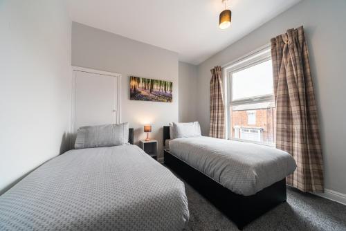 赫尔3 Bedroom Hull Sleeps 6 Glam Contractor & Leisure & Families的卧室设有两张床,带窗户