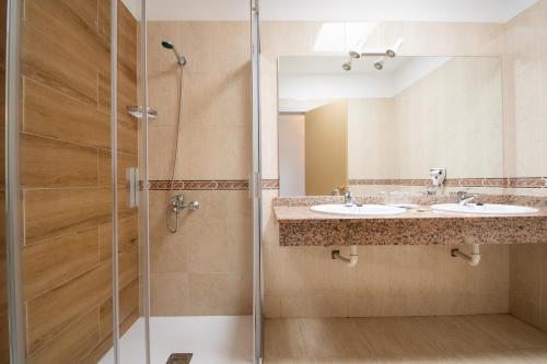 普拉亚布兰卡普拉亚布兰卡俱乐部酒店的一间带两个盥洗盆和淋浴的浴室