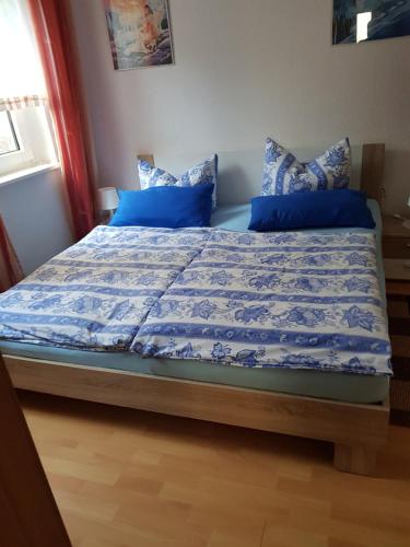克吕茨Mühlenblick的卧室内的一张带蓝色床单和枕头的床