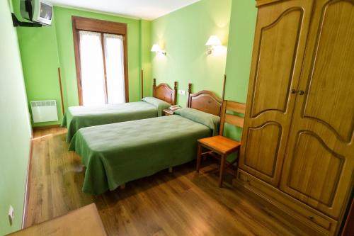 坎加斯-德奥尼斯Pension Monteverde的绿色客房 - 带两张床和一张沙发