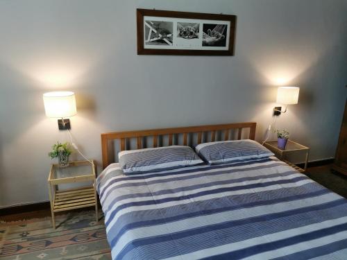 比耶拉In centro da Laura, Via Repubblica 49 BI的一间卧室配有一张带2个床头柜和2盏灯的床。