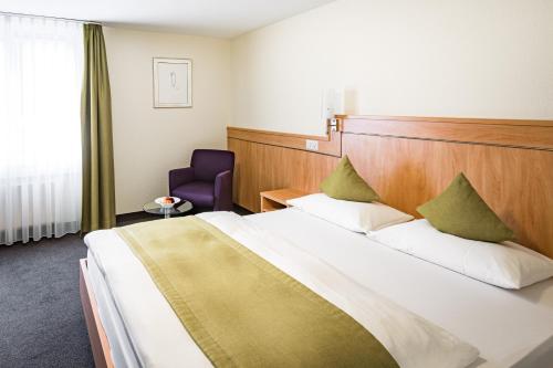 布克斯布克斯霍夫酒店的酒店客房设有一张大床和一张紫色椅子