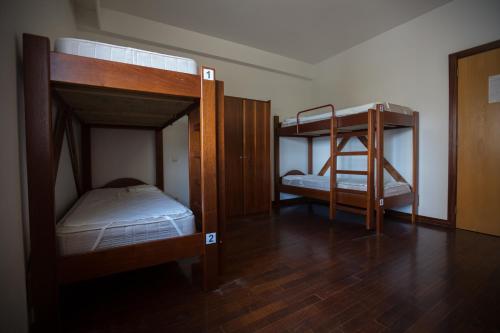 福什科阿新镇HI Foz Coa - Pousada de Juventude的铺有木地板的客房内配有两张双层床。