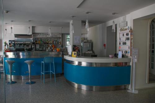 贝拉里亚-伊贾马里纳阿德里亚酒店的餐厅内的酒吧,设有蓝色柜台和凳子