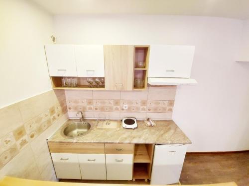 贝尔格莱德MAGENTA Apartments的厨房配有水槽和白色橱柜
