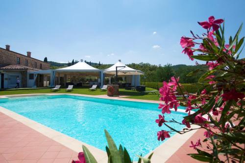 MontefollonicoPoggio Paradiso Resort & Spa的鲜花庭院中的游泳池