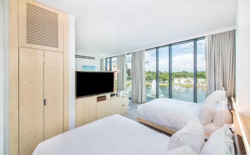 盖恩斯维尔Hotel Eleo at the University of Florida的酒店客房设有两张床和一台平面电视。