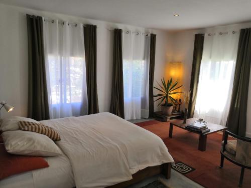 塔那那利佛曼德罗索庄园旅馆的卧室设有白色的床和大窗户