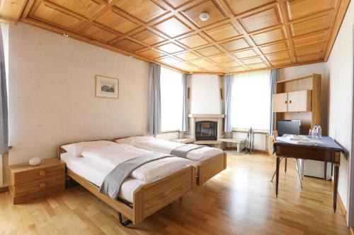Niederuzwilhotel löwen的一间卧室配有一张床和一张书桌