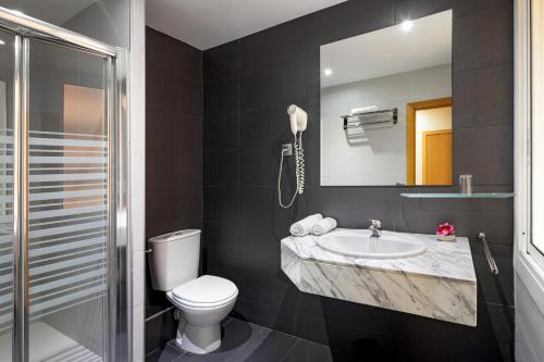 巴塞罗那加泰罗尼亚酒店的一间带水槽、卫生间和镜子的浴室
