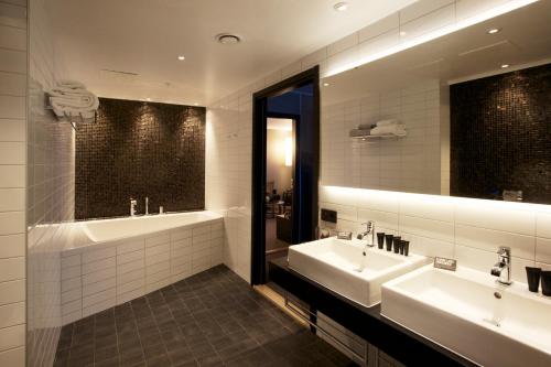 吕勒奥森斯克拉丽奥酒店的一间带两个盥洗盆和大镜子的浴室