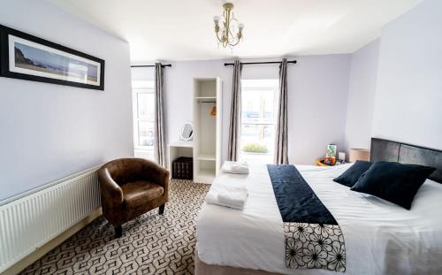 莫维尔温馨小屋式酒店的一间卧室配有一张大床和一把椅子