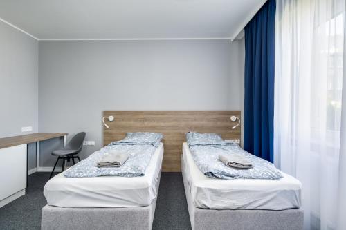 格丁尼亚Hugo的带窗户的客房内设有两张单人床。