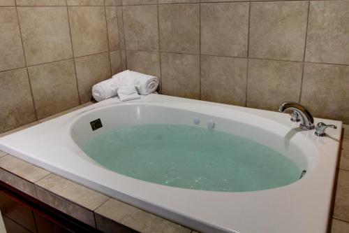 CarringtonCobblestone Inn & Suites - Carrington的瓷砖浴室设有浴缸。