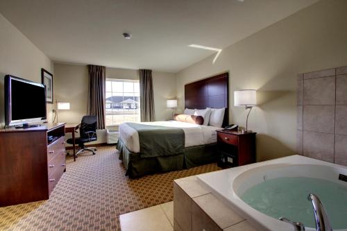 CarringtonCobblestone Inn & Suites - Carrington的酒店客房带一张床和浴缸