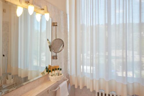 塔皮安诺普拉扎酒店的浴室设有镜子和浴帘