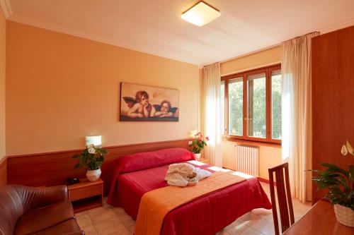 塔皮安诺普拉扎酒店的一间卧室配有一张床、一张桌子和一个窗户。