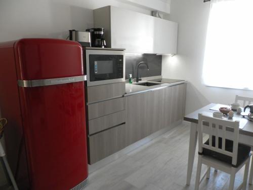 阿科La casa di Virginia的厨房配有红色冰箱和水槽