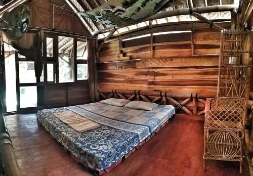 KalakHarry's Ocean House Watukarung Homestay的木墙客房的一张床位
