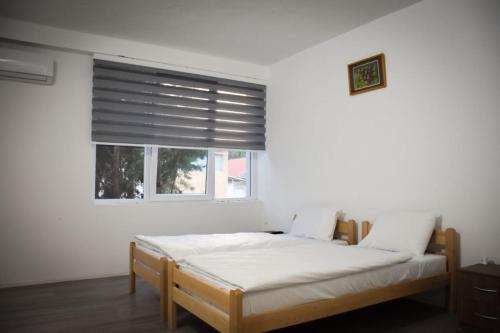 VinicaVila Oska的一间卧室配有一张床和一个带百叶窗的窗户