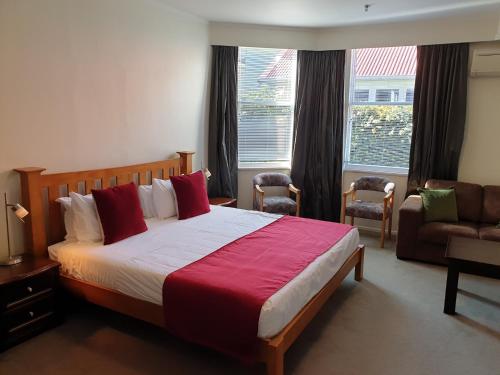 奥克兰At Eden Park Motel的一间卧室配有一张床、一张沙发和一个窗口