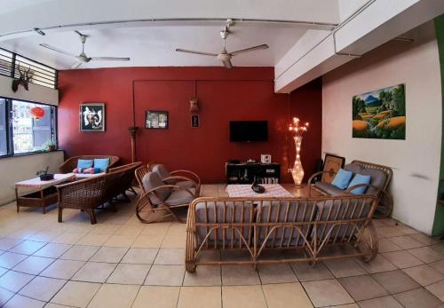 哥打京那巴鲁神山青年旅社的客厅设有红色的墙壁和桌椅