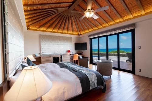 宫古岛维拉布度假酒店的一间卧室设有一张床,享有海景