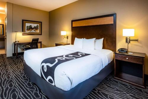 尤金尤金拉昆塔套房酒店的酒店客房带一张大床,带白色床单