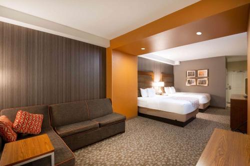 杜兰戈La Quinta by Wyndham Durango的酒店客房,配有床和沙发