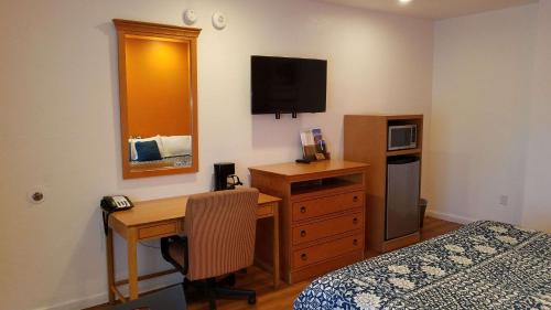 阿拉米达Rodeway Inn Alameda-Oakland的一间卧室配有一张桌子和一张床,一张书桌和一台电脑