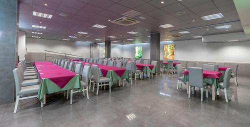 卡塔赫纳马诺洛酒店的一间用餐室,配有红色和绿色的桌椅