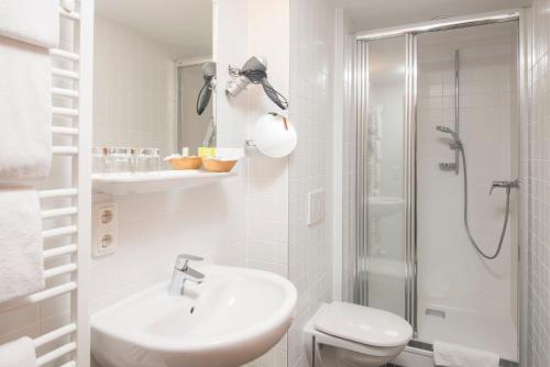 魏茨埃德尔酒店的白色的浴室设有水槽和淋浴。