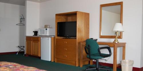 HillsboroCountry Haven Inn的一间卧室配有书桌、椅子和电视。