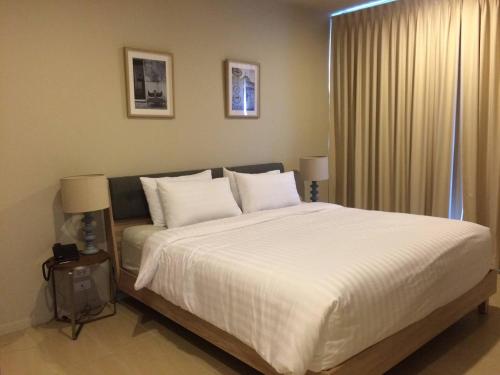 Ban Bo KhaemBeach Front Condo, Baan Thew Talay, Perfect Choice for Family and Couple的卧室配有一张带白色床单和枕头的大床。