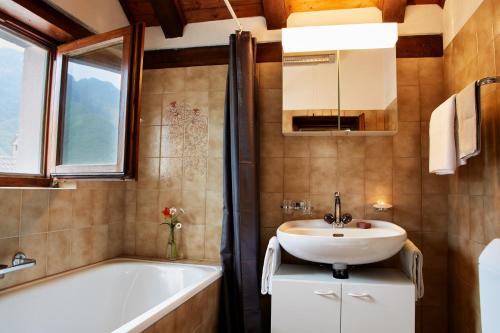 CranaWild Valley Romantic Escape的浴室配有盥洗盆、浴缸和镜子