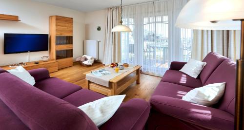 比苏姆Haus EbenEzer的客厅配有两张紫色沙发和一台电视机